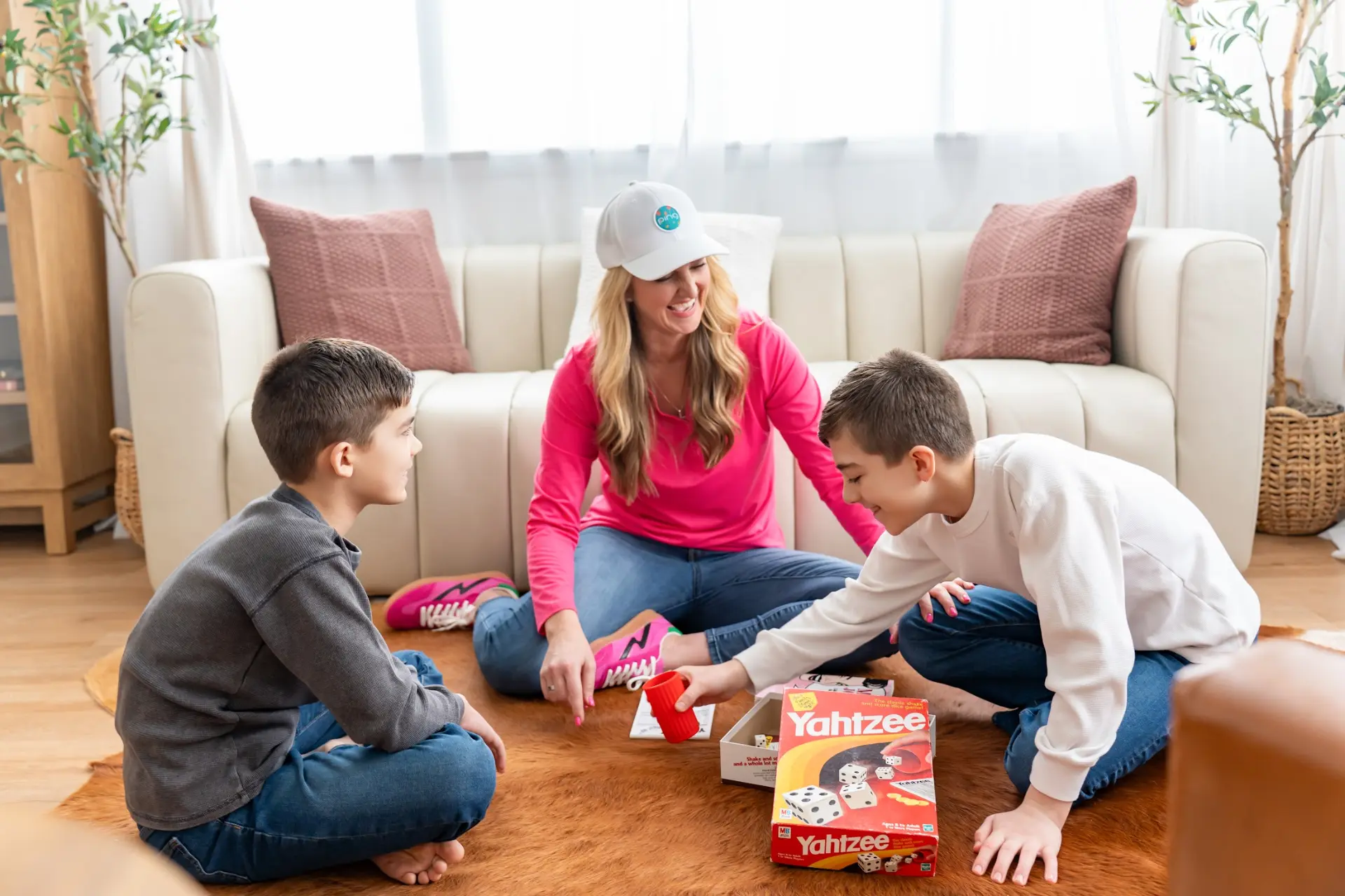 Holly Marie Thomson playing a board game with her sons in a living room